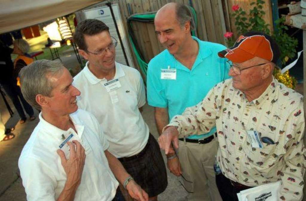 Coach (orange cap) visiting at a swimmiing reunion 